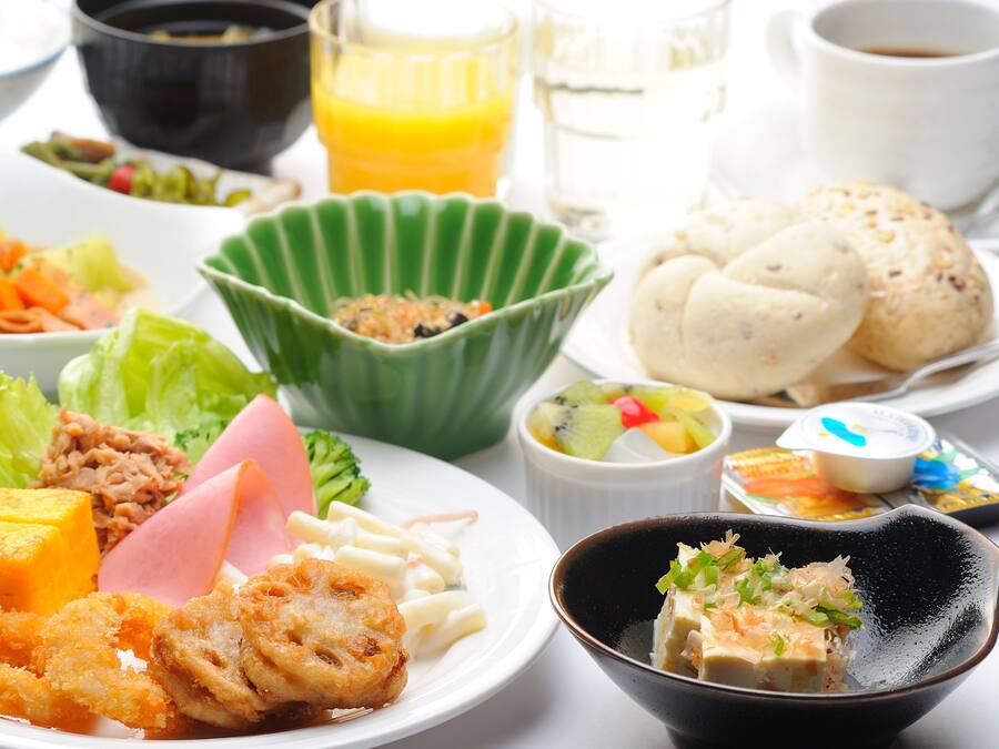 A variety of dishes including fried items, a bowl of salad, and a cup of coffee.