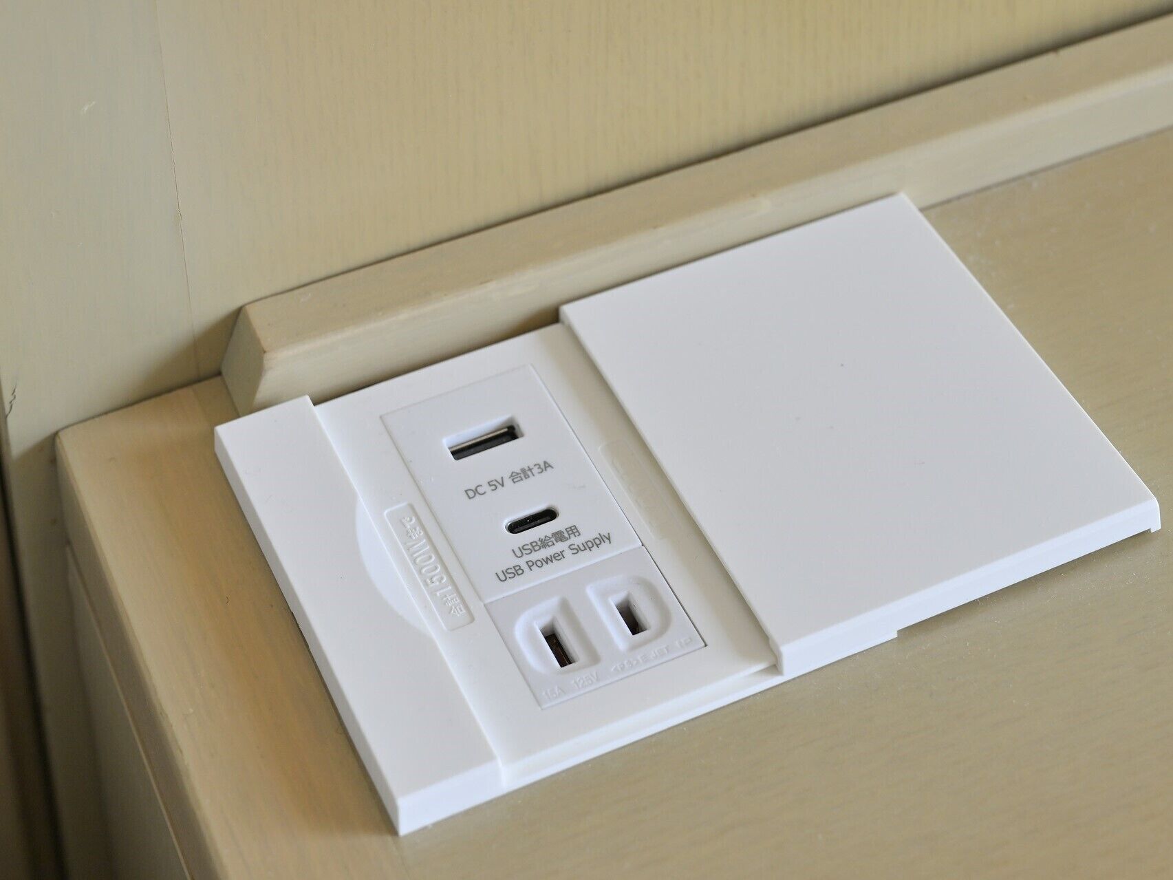 A white power strip with a USB port and a label indicating it is a DC 5V combined 3A.