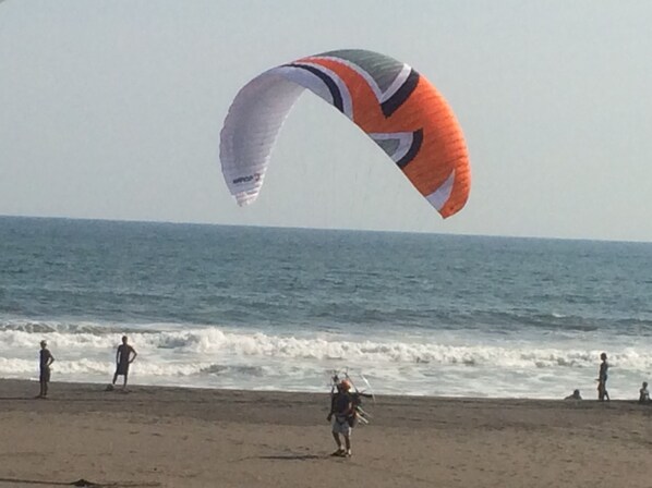 Una playa con gente y una cometa grande.