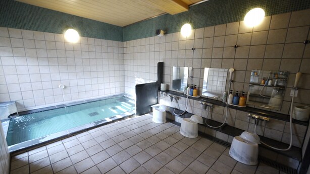 A bathroom with a tiled floor, a bathtub, a sink, and a mirror. - Hotel Route Inn Oita Ekimae (Oita)