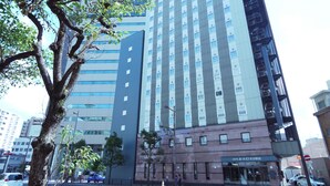 A multi-story hotel with a modern facade, featuring a prominent sign at the top. - Hotel Route Inn Oita Ekimae (Oita)