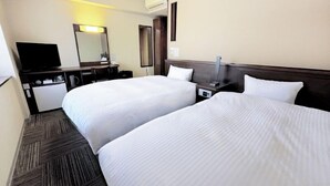 Une chambre d’hôtel avec deux lits, un bureau, une chaise, une télévision et un appareil de climatisation.