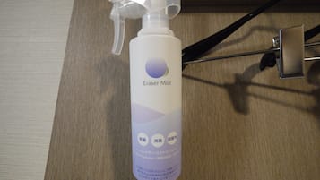 Une bouteille de produit effaçant en aérosol, dotée d’un embout pulvérisateur, posée sur une surface en bois.