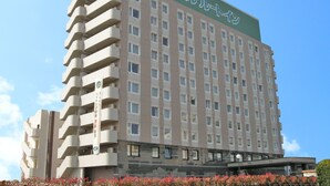 A multi-story hotel with a green roof and a sign in Japanese. - Hotel Route Inn Yatsushiro (Yatsushiro)