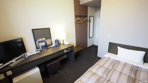 A hotel room with a bed, a desk with a computer, a telephone, a coffee maker, and a mini-fridge. - Hotel Route-Inn Court Matsumoto Inter (Matsumoto)
