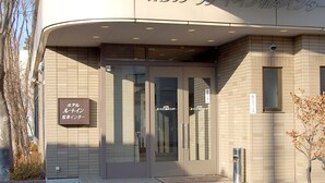 A hotel entrance with a glass door, a signboard, and a tiled facade. - Hotel Route-Inn Court Matsumoto Inter (Matsumoto)