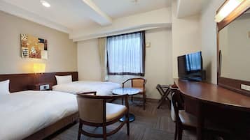 Habitació d'hotel amb dos llits, escriptori amb televisió, cadira i finestra amb cortines.