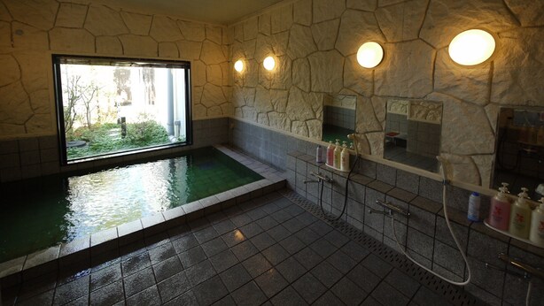 A stone-walled spa room with a large window, a small pool, and a shower area. - Hotel Route-Inn Court Uenohara (Uenohara)