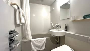 Une salle de bain avec une baignoire, un lavabo, un miroir et un porte-serviettes.