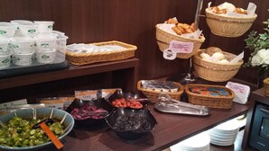 A buffet setup with various food items, baskets, and serving utensils.