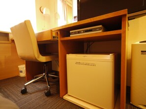 A compact office space with a desk, chair, and a small white refrigerator. - Hotel Route - Inn Satsuma Sendai (Satsumasendai)