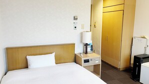 A hotel room with a bed, a bedside table with a lamp, a phone, and a minibar. - Hotel Route-Inn Seibu Chichibu Ekimae (Chichibu)