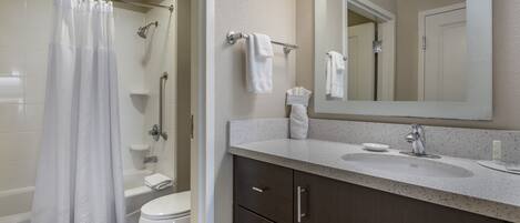 A modern bathroom with a bathtub, toilet, and sink.