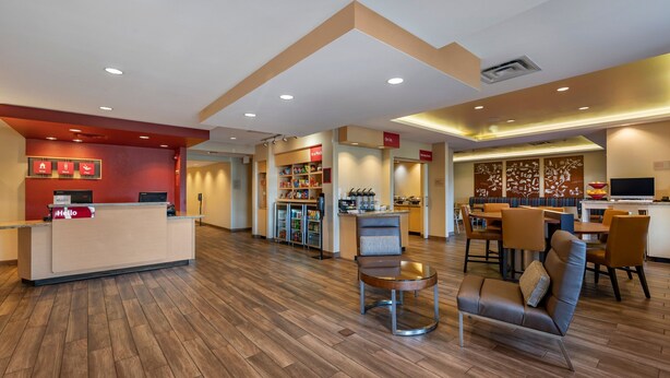 Un hall de hotel con mostrador de recepción, zona de estar y kitchenette.