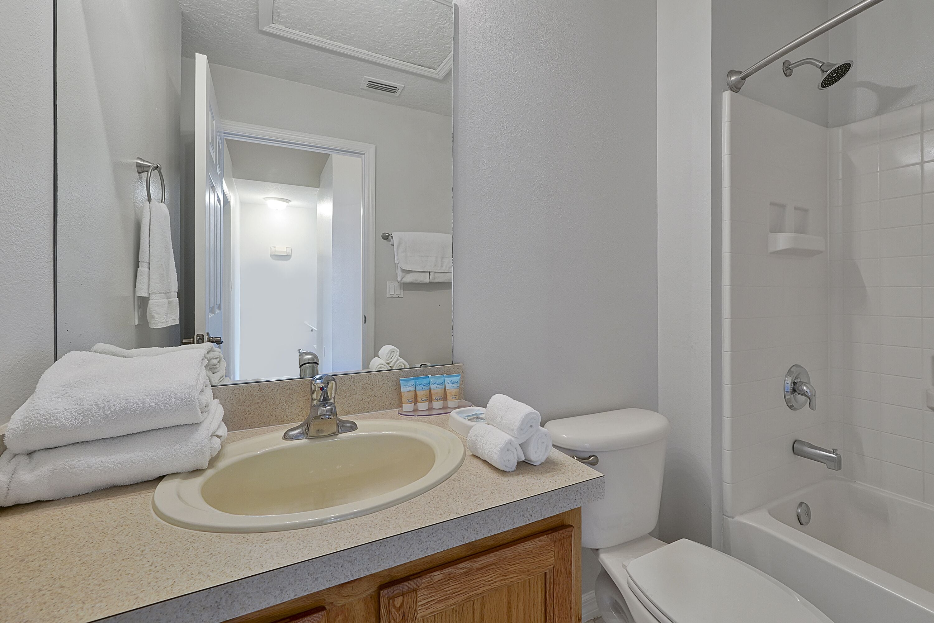 A bathroom with a sink, toilet, and shower.
