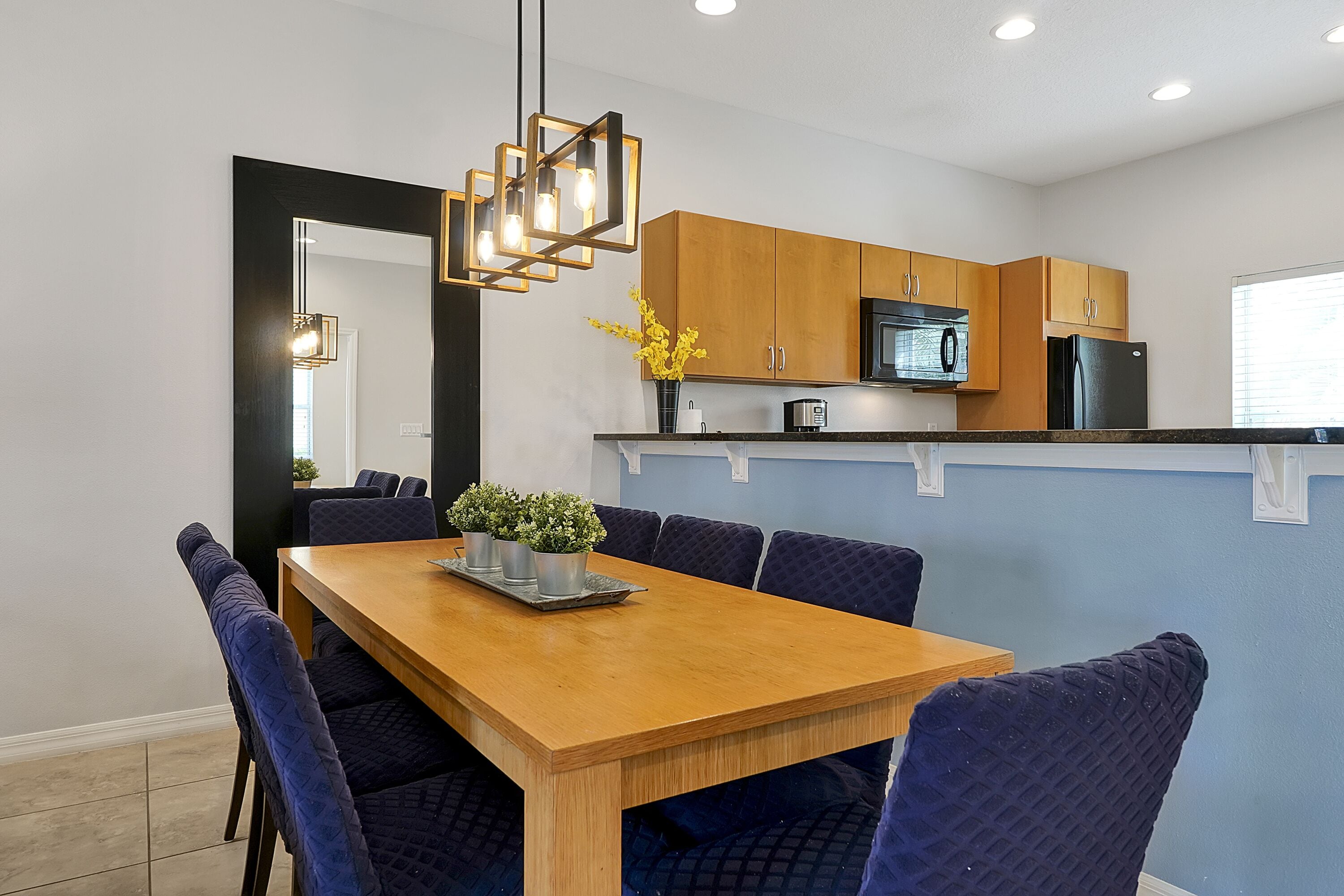 A modern kitchen with wooden cabinets, a microwave, and a refrigerator.