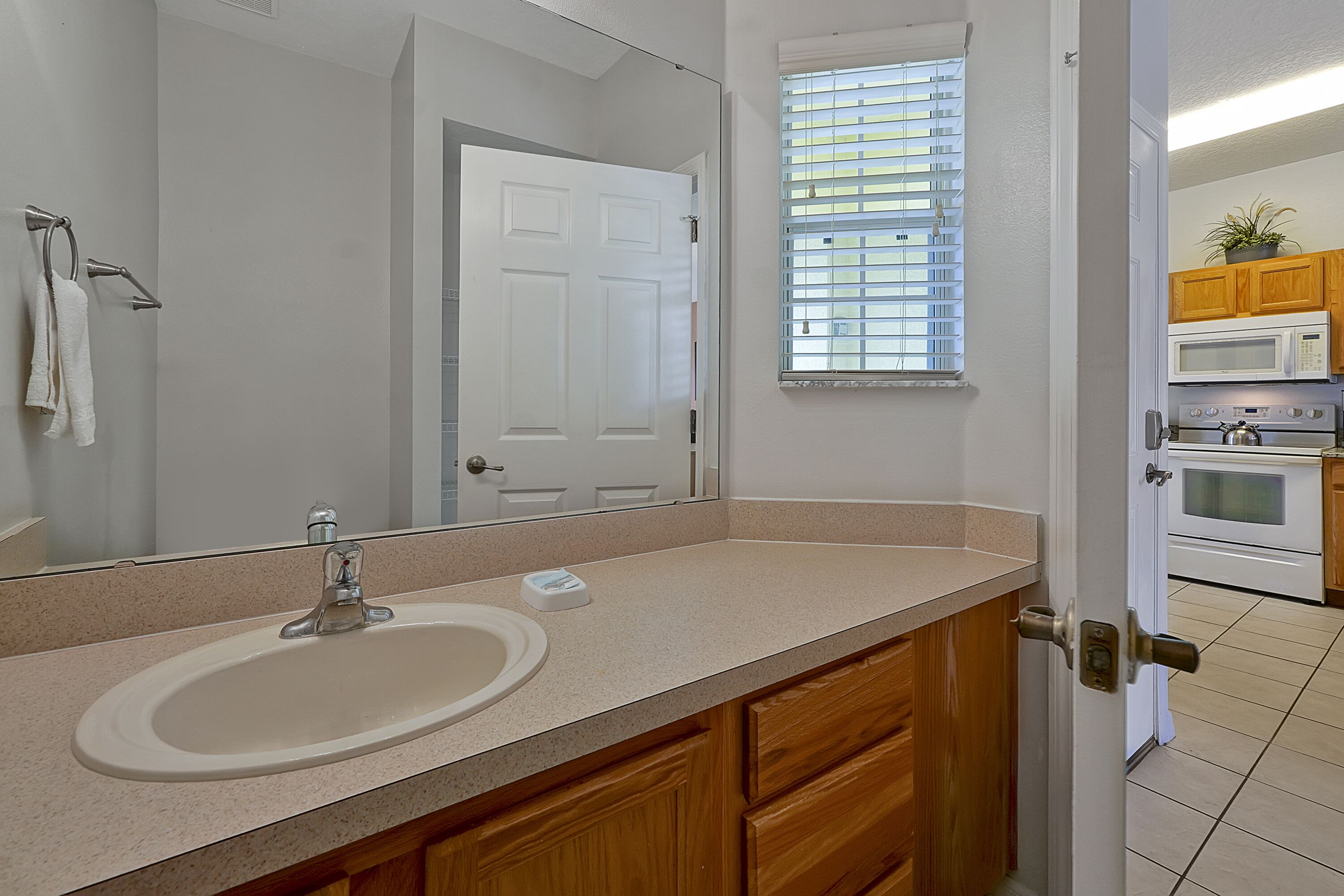 A bathroom with a sink, mirror, and wooden cabinets.