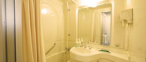 A bathroom with a bathtub, a sink, a toilet, and a mirror.