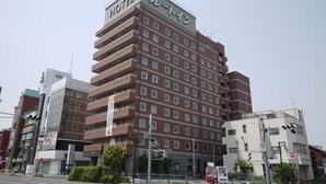 Un hotel de varios pisos con un llamativo letrero que dice 'HOTEL' en la parte superior.
