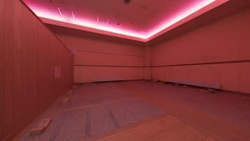 A room with wooden panel walls, a tiled floor, and a ceiling with recessed lighting.