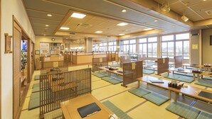 Une auberge japonaise traditionnelle dotée de tatamis, de cloisons en bois et d’un espace de réception avec un comptoir et divers équipements.