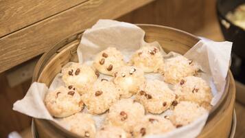 A steamer basket with steamed buns and beans.
