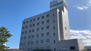 A multi-story building with a flat facade, numerous windows, and a rooftop structure. - Hotel Route-Inn Itoigawa (Itoigawa)