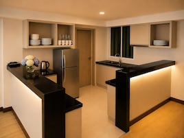 Cocina compacta con refrigerador integrado, un lavamanos y una encimera con un florero.