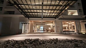 A modern building with a covered entrance, a reception area, and a view into the interior. - Blanco Apartment Hotel (Bintulu)
