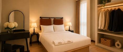 A hotel room with a bed, bedside tables, a mirror, a desk, and a wardrobe.