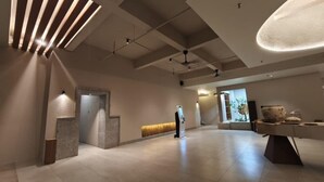 A spacious lobby with a reception desk, a self-service kiosk, and a seating area with a decorative vase. - Blanco Apartment Hotel (Bintulu)