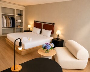 A hotel room with a bed, bedside tables, a chair, a small table with flowers, and a wardrobe. - Blanco Apartment Hotel (Bintulu)