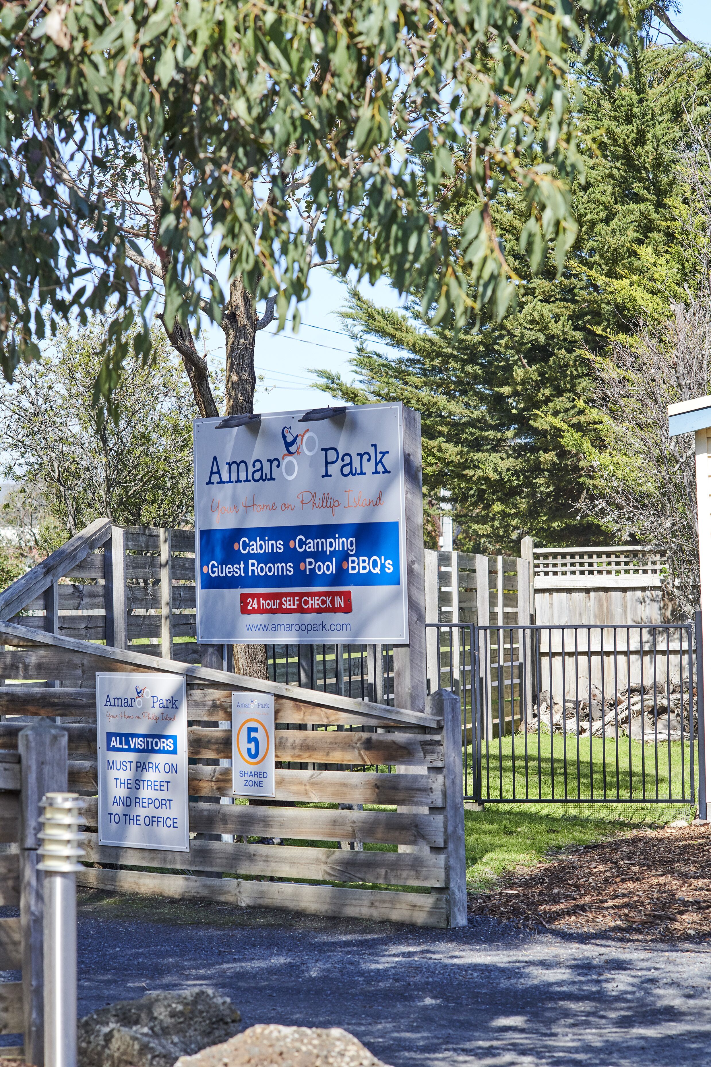 Señal de Amar Park con servicios como cabañas, camping, habitaciones de huéspedes, piscina y barbacoas.
