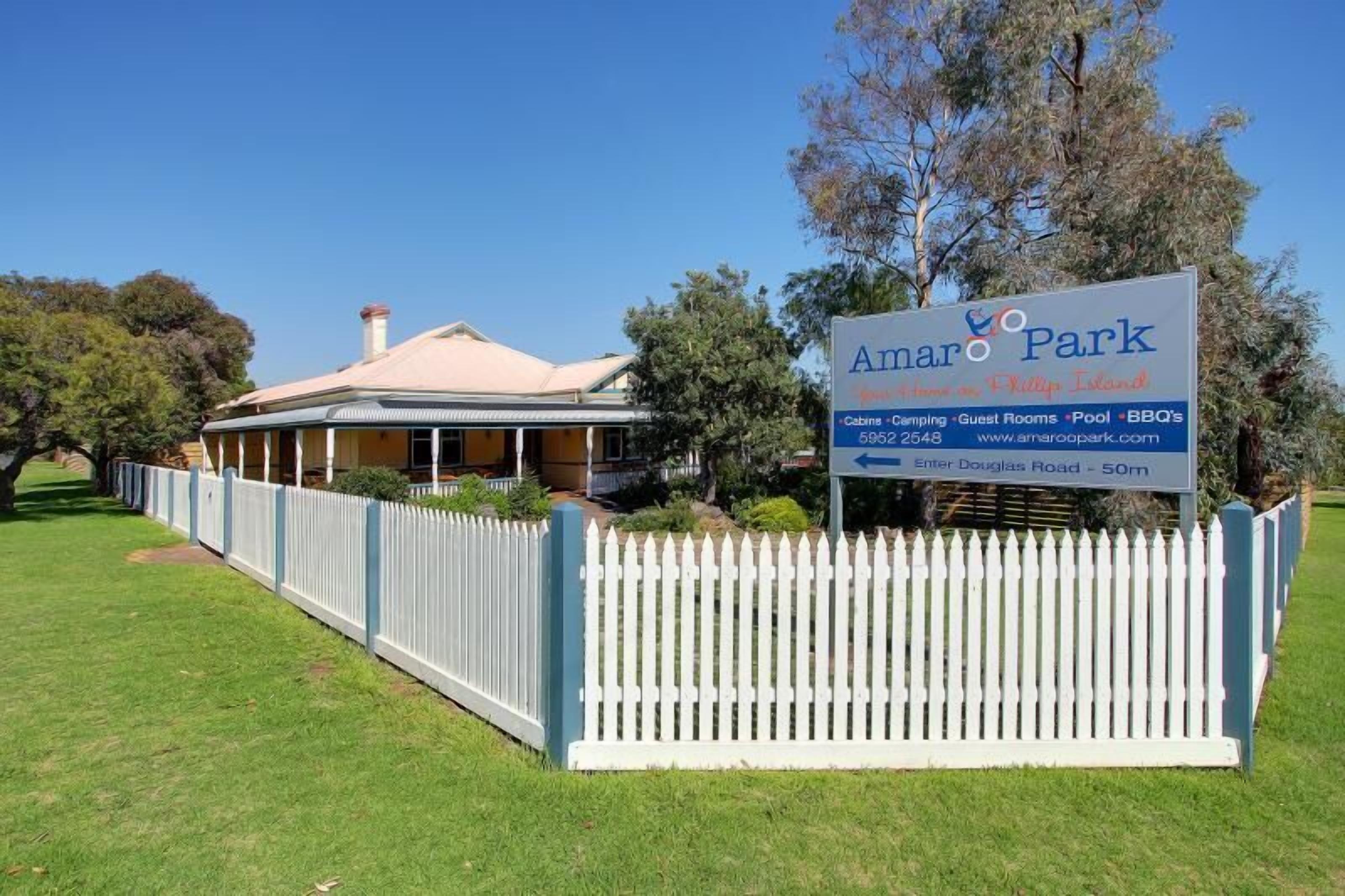 A sign for Amaroo Park with amenities including cabins, camping, guest rooms, pool, and BBQs.