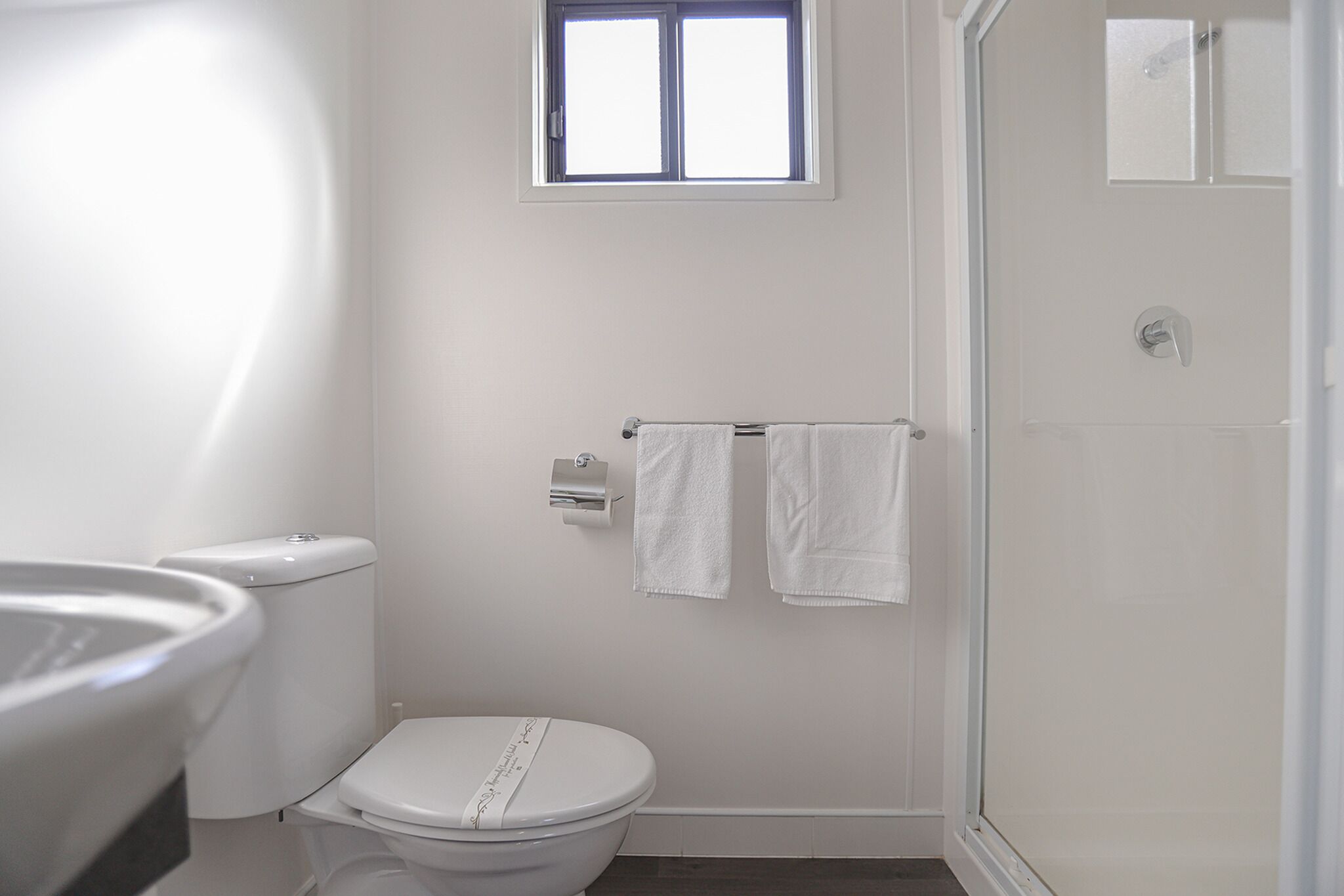 Un baño con inodoro, ventana y zona de ducha.