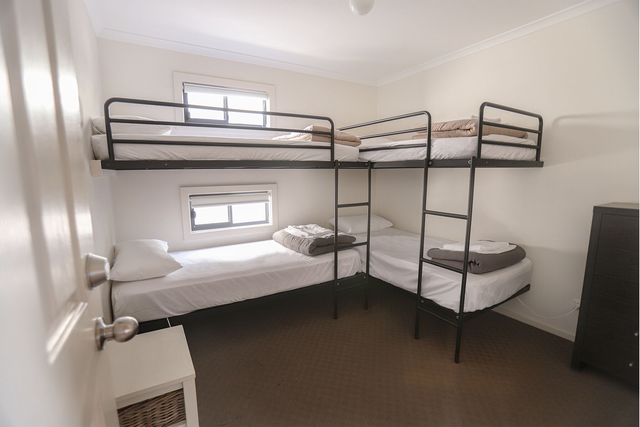 Un dormitorio con literas, una ventana y una puerta.