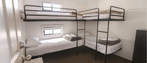 Un dormitorio con literas, una ventana y una puerta.