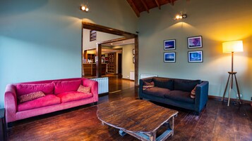 Un salón amplio con dos sofás, una mesa de centro de madera y una lámpara de pie.
