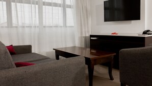 Una sala de estar moderna con un sofá, una mesa de centro y un televisor montado en la pared.
