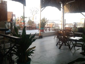 An outdoor seating area with wicker furniture and potted plants. - Anoop Hotel (New Delhi)