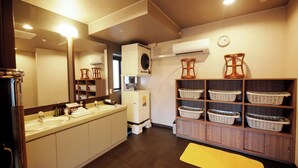 A hotel bathroom with a large mirror, a sink, and shelves with baskets. - Hotel Route-Inn Court Minami Matsumoto (Matsumoto)
