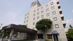A multi-story hotel with a modern facade, a covered entrance, and a tree in front. - Hotel Route-Inn Court Minami Matsumoto (Matsumoto)
