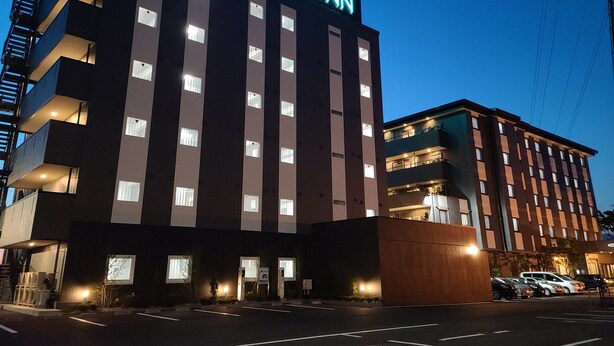 Un hotel de varios pisos con un letrero llamativo que dice 'HOTEL ROUTE INN'.