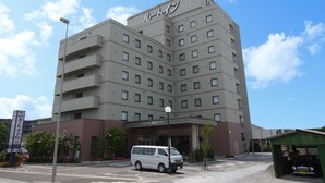 A multi-story hotel with a flat facade, numerous windows, and a sign with non-English characters.