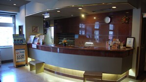 A reception desk with a clock, a bulletin board, and a vending machine. - Hotel Route-Inn Ueda - Route 18 (Ueda)