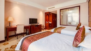 A hotel room with a bed, a desk, a television, and a wardrobe.