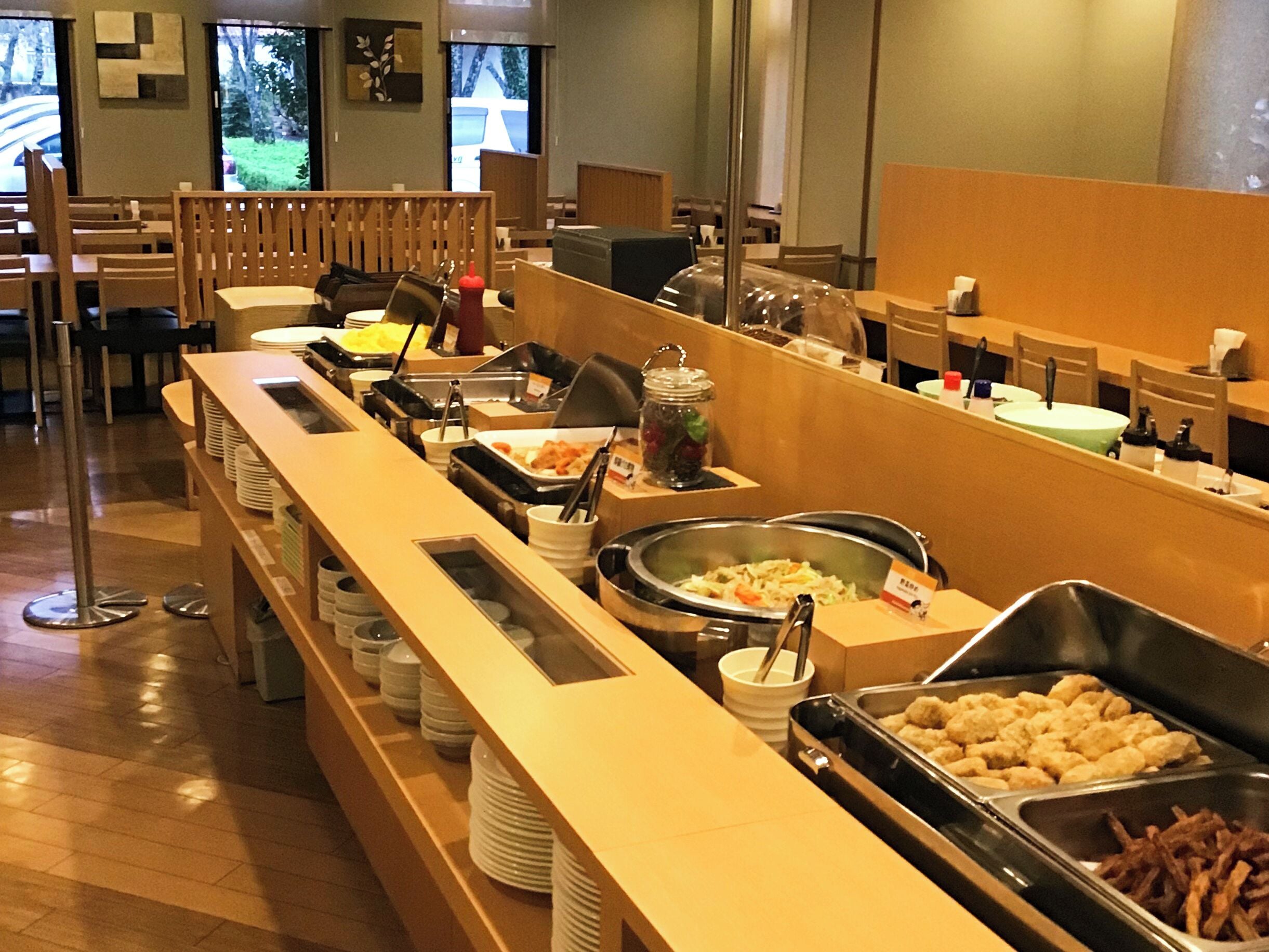 A buffet setup with various food items and utensils.