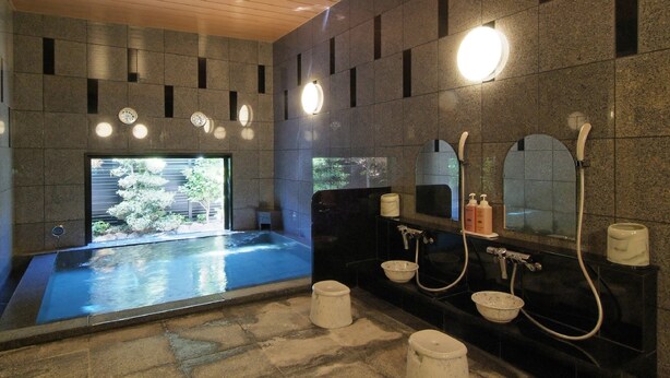 A modern bathroom with a large bathtub, a separate shower area, and a sink with multiple faucets. - Hotel Route-Inn Shin Gotenba Inter (Gotemba)