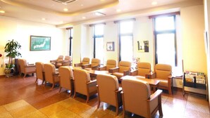A conference room with beige chairs and tables, large windows, and a map on the wall. - Hotel Route-Inn Shin Gotenba Inter (Gotemba)