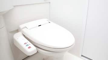 Un inodoro moderno con un panel de control, una pared blanca y una puerta.